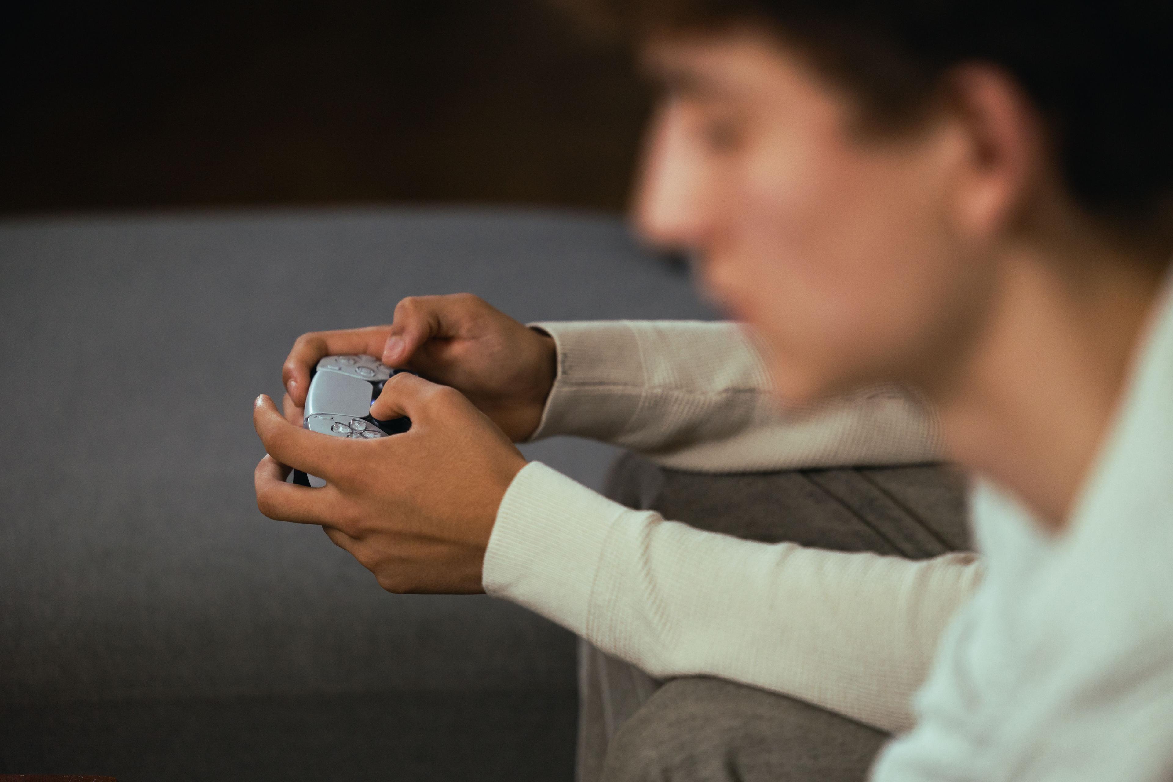 Nærbillede af ung person der holder joystick