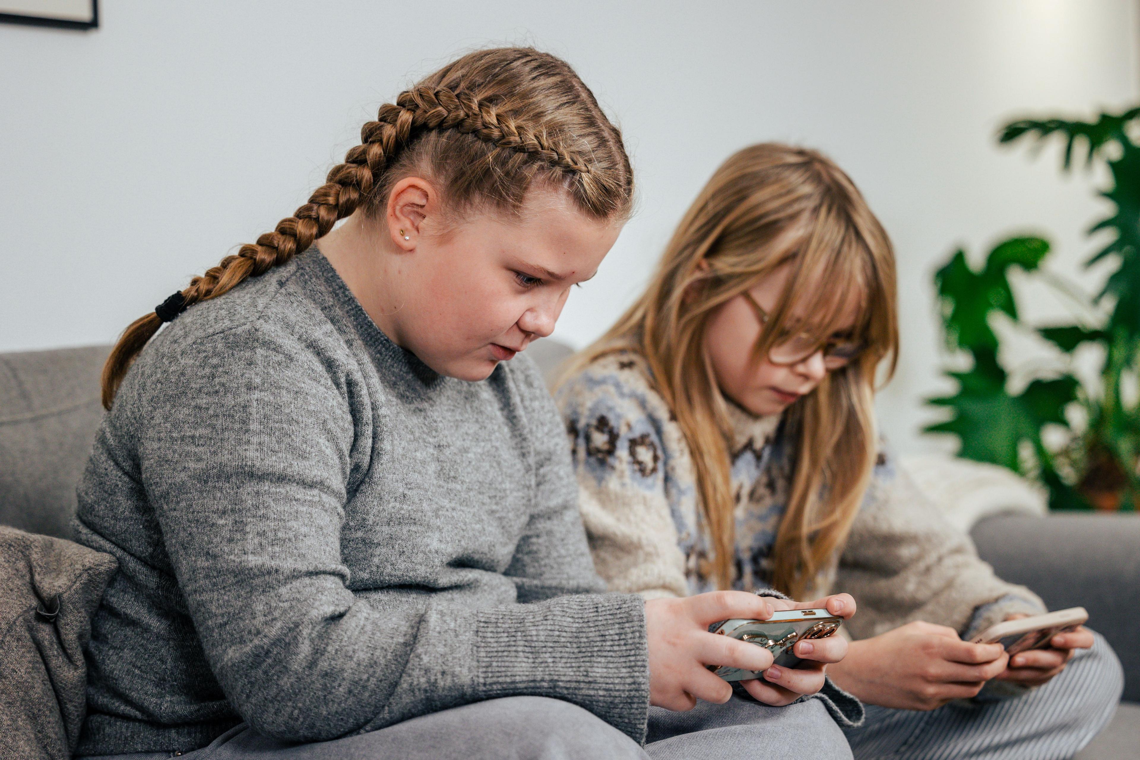 Teenager kigger ned i hver deres smartphone