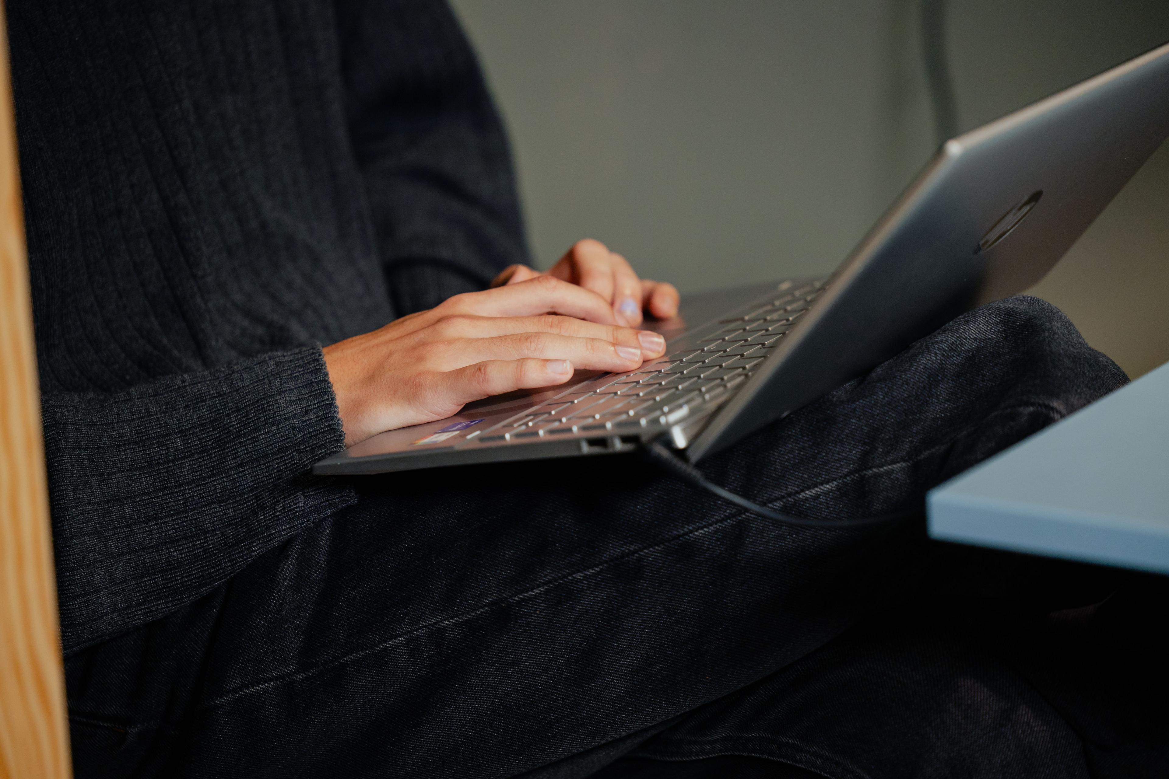 Teenagedreng på computeren med computeren i fokus