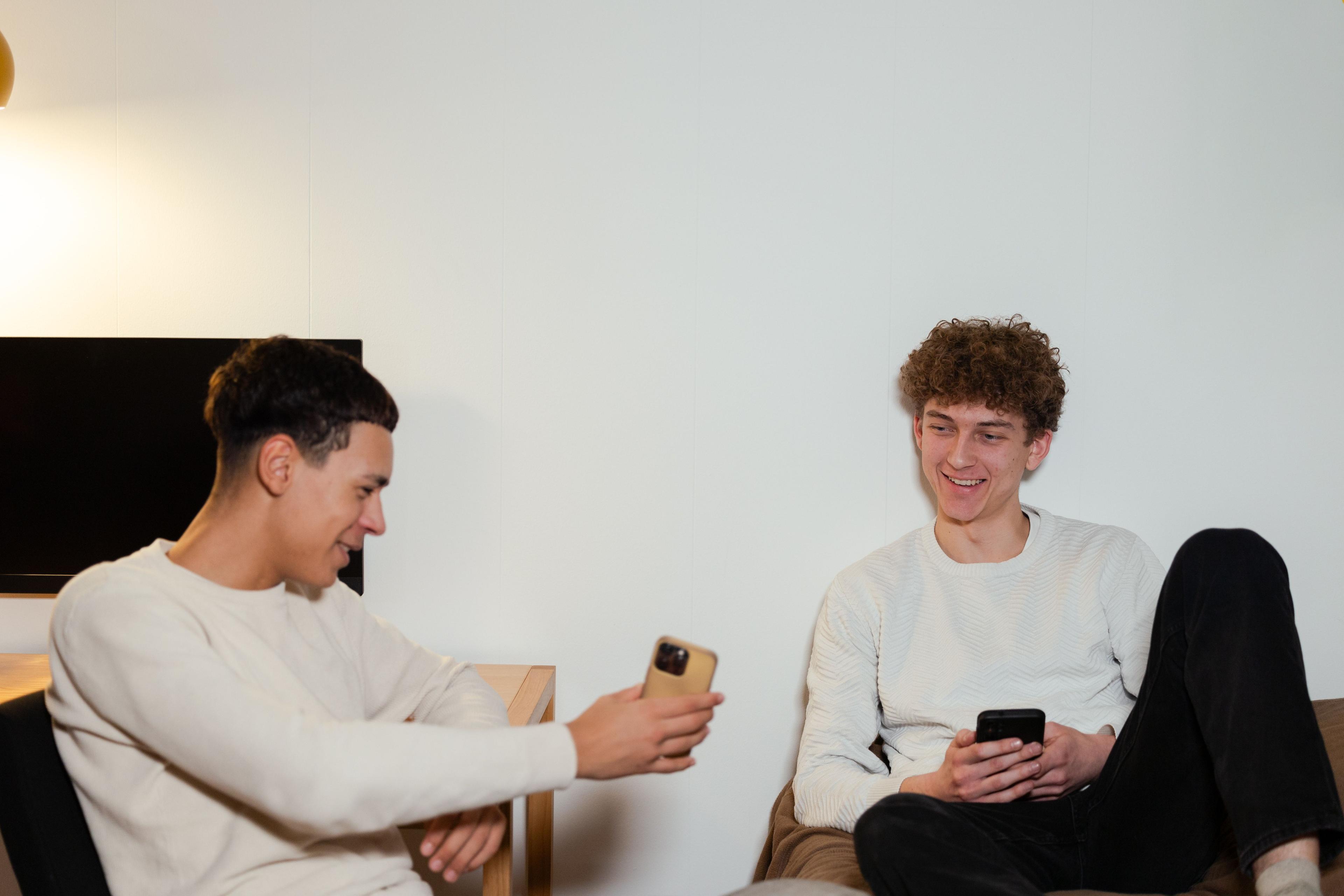Teenager viser noget på sin smartphone til en anden