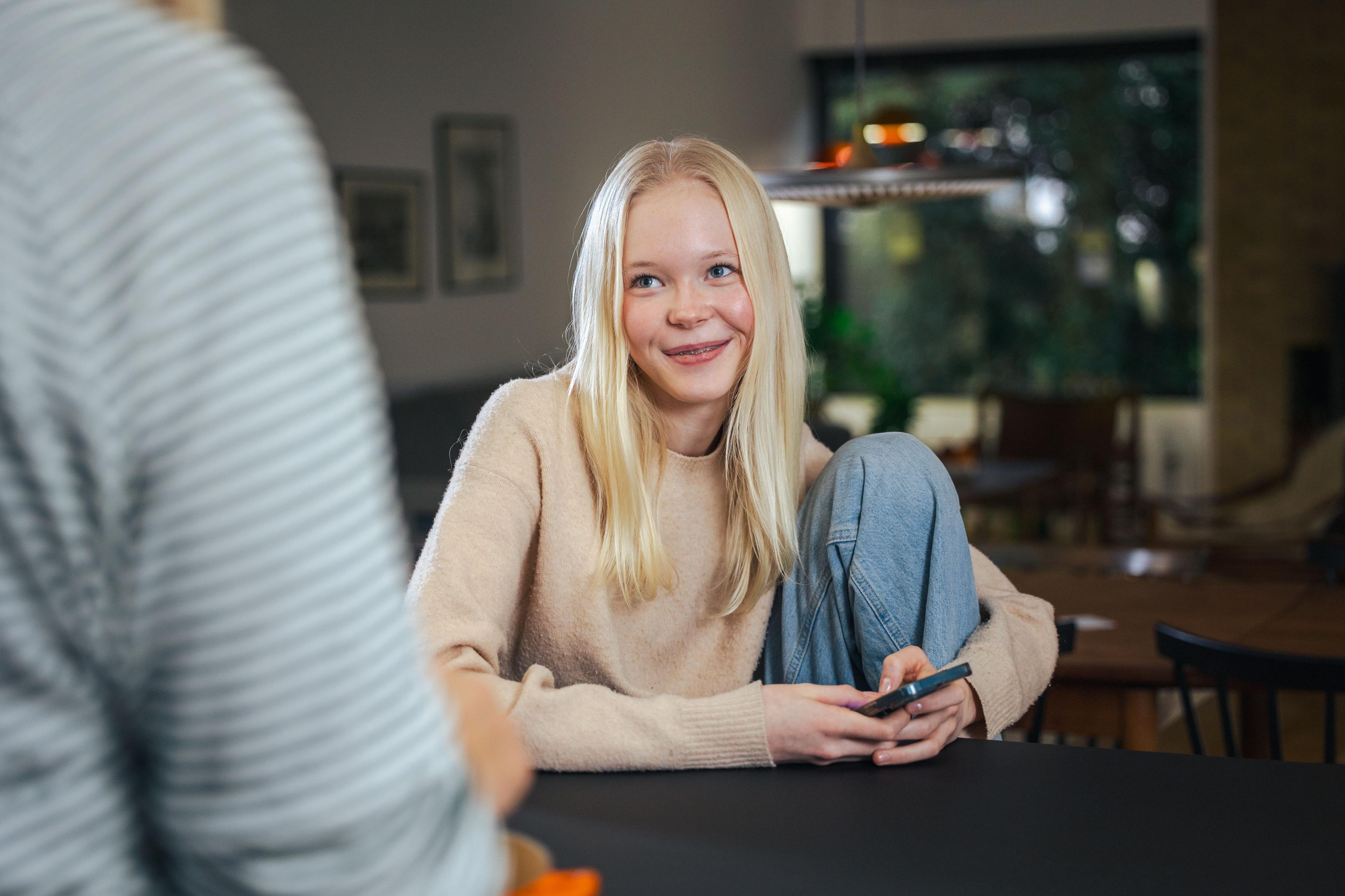 Teenager kigger op fra smartphone