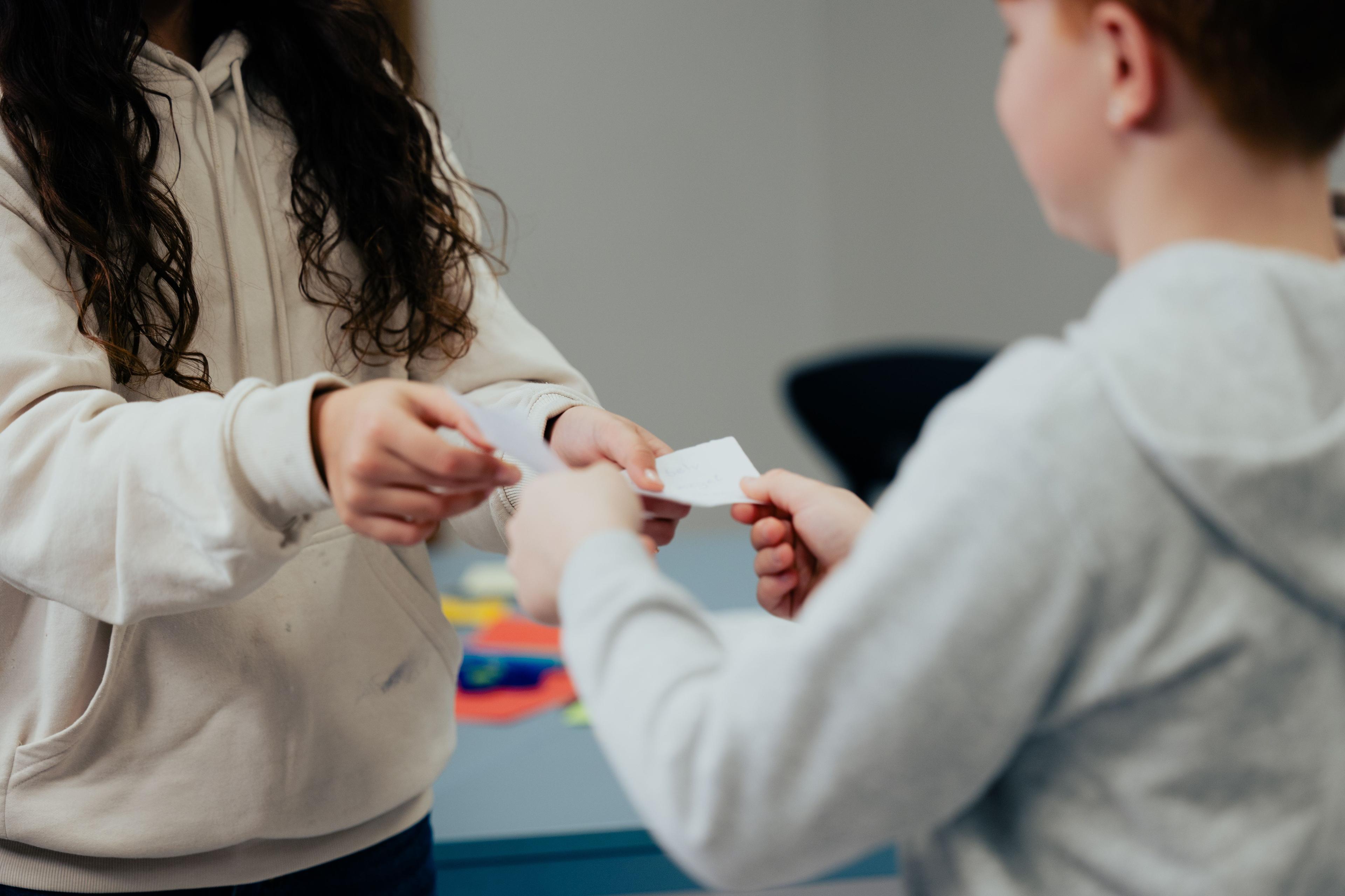 En pige og drenge står og arbejder med en øvelse fra On